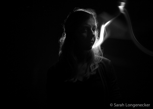 Woman looking mysterious with light like smoke behind her head