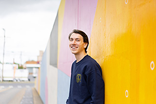 thomas erickson standing in front of a colorful wall