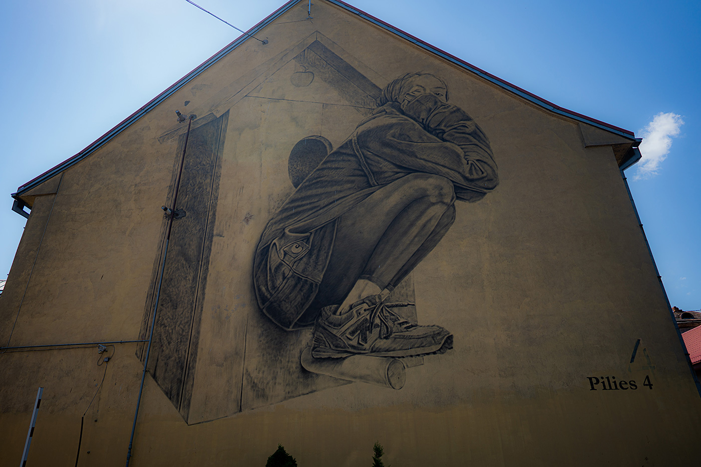 A mural of a woman perched on a birdhouse