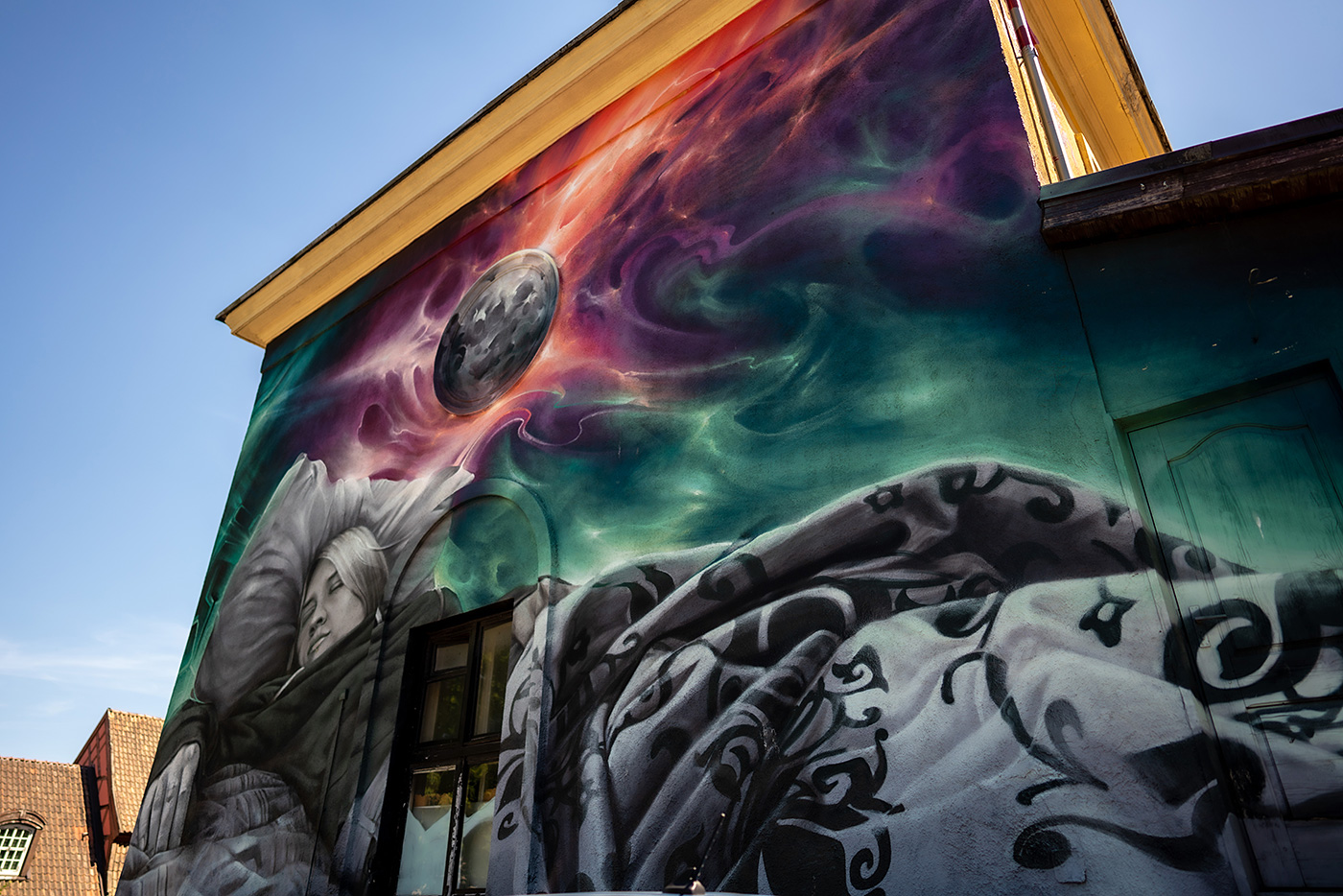 A mural of a woman sleeping under a vibrant sky