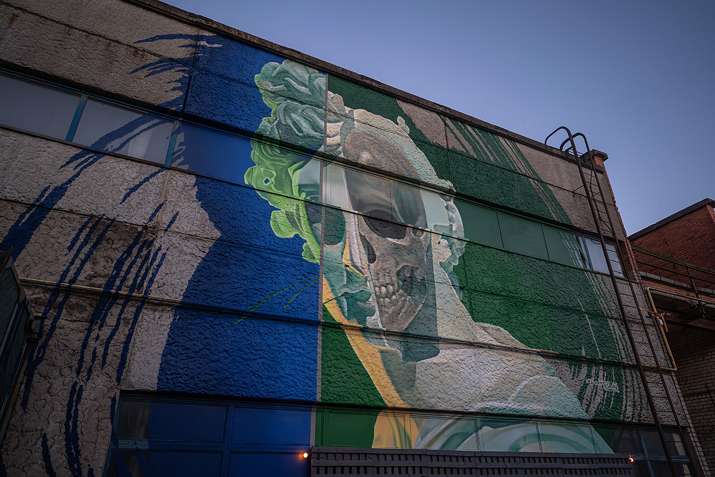 A mural of a skeleton within a sculpture on a blue and green background