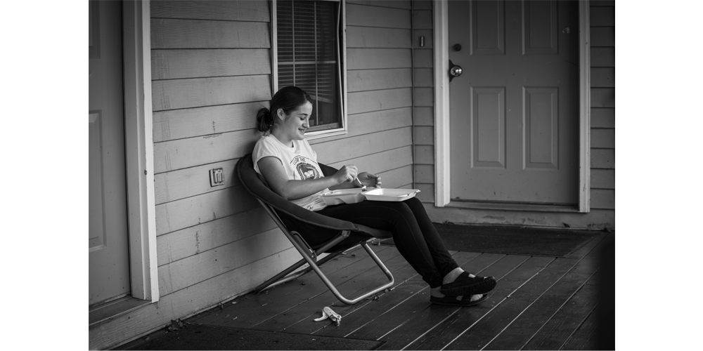 Jenna eats lunch from the cafeteria and enjoys the fresh air.