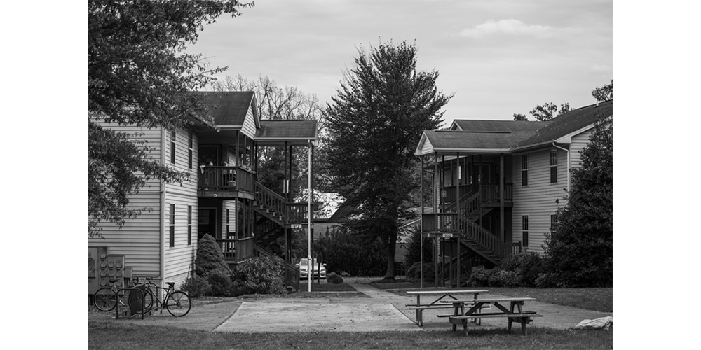 EMU residents sit together on the top floor of the apartments to talk, eat lunch, and enjoy the sunshine.