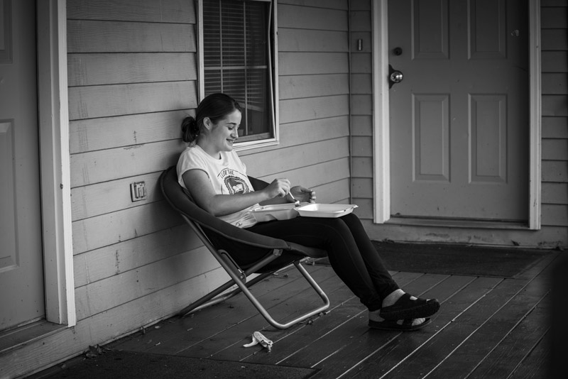 Jenna eats lunch from the cafeteria and enjoys the fresh air.